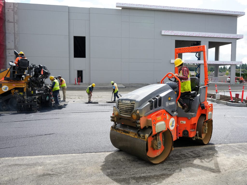 Roller and paver laying a new commercial parking lot