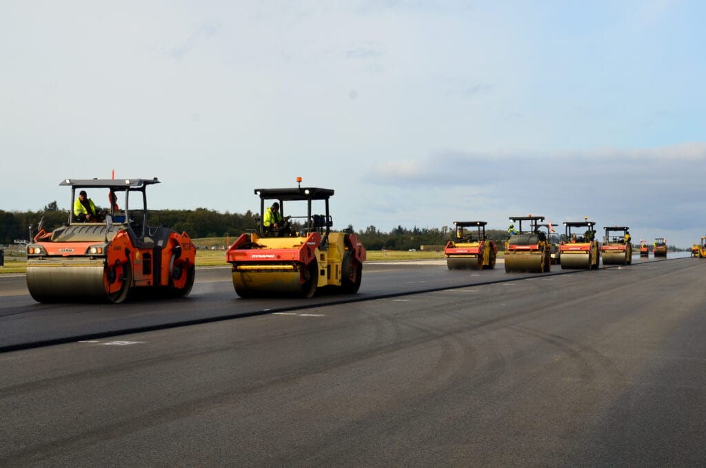 Rollers compacting new asphalt on an airfield runway